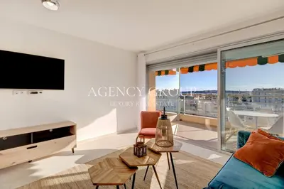 a living room with a tv and a large window at Appartement 3P - Vue Mer - Proche de la Croisette in Cannes