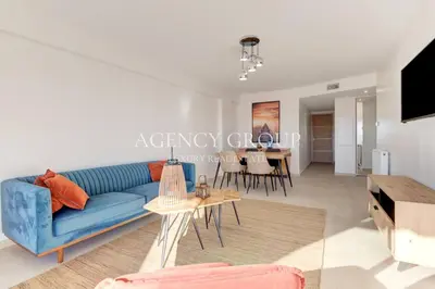 a living room with a blue couch and a table at Appartement 3P - Vue Mer - Proche de la Croisette in Cannes
