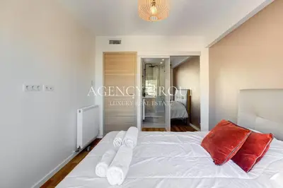 a bedroom with a white bed with red pillows at Appartement 3P - Vue Mer - Proche de la Croisette in Cannes