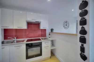 a kitchen with white cabinets and red tiles at Confortable Studio BALCON, Rouaze- CARLON MARTINEZ A0B123 in Cannes