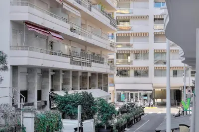 a tall white building with trees in front of it at Confortable Studio BALCON, Rouaze- CARLON MARTINEZ A0B123 in Cannes