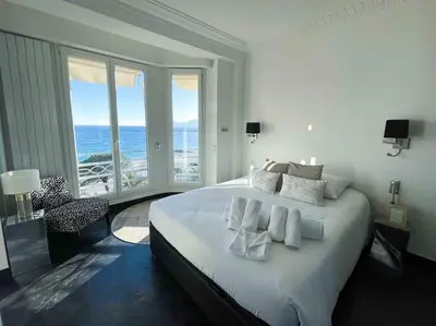 a bedroom with a large bed with a view of the ocean at Stunning 2 bedroom flat with sea view on Croisette in Cannes