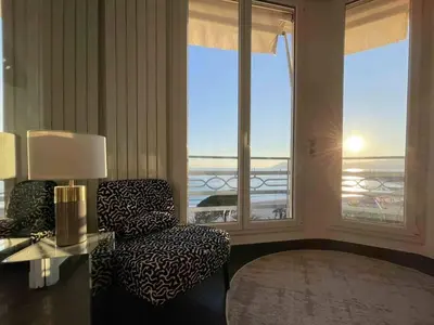 a living room with a chair and a window at Stunning 2 bedroom flat with sea view on Croisette in Cannes