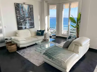 a living room with a white couch and a glass table at Stunning 2 bedroom flat with sea view on Croisette in Cannes