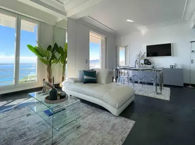 a living room with a white couch and a table at Stunning 2 bedroom flat with sea view on Croisette in Cannes