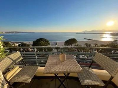 a table and chairs on a balcony with a view of the ocean at Stunning 2 bedroom flat with sea view on Croisette in Cannes