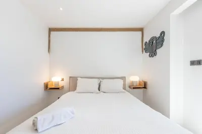 a bedroom with a white bed with two lamps at LB Vacation Rentals I A short Stroll to Palais, Beach, Terrace & Seaview in Cannes