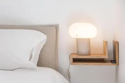 a bed with a lamp on a night stand next to a bed at LB Vacation Rentals I A short Stroll to Palais, Beach, Terrace & Seaview in Cannes