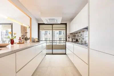 a kitchen with white cabinets and a large window at LB Vacation Rentals I A short Stroll to Palais, Beach, Terrace & Seaview in Cannes