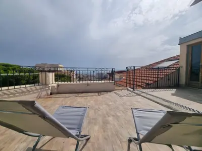 a pair of chairs on a deck with the ocean at Appartement Grasse Toit Terrasse in Cannes
