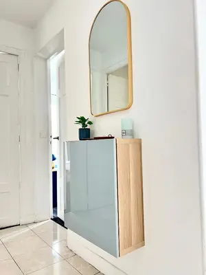 a mirror on a white wall next to a cabinet at Fiorella's Cannes Oasis in Cannes