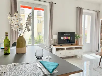a table with wine glasses and a vase with flowers at Fiorella's Cannes Oasis in Cannes