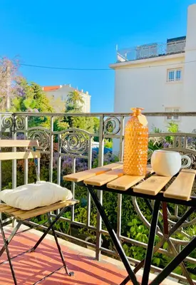 a table and chairs on a balcony with a vase at Fiorella's Cannes Oasis in Cannes