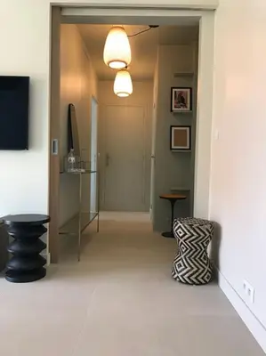 a room with a hallway with a chair and a door at Superbe Appartement Cannes - 50m2 & Terrasse - Très Proche Croisette in Cannes
