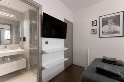 a bathroom with a sink and a tv and a mirror at Palais Des Iles - La Croisette by Halldis in Cannes