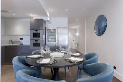 a dining room with a table and blue chairs at Palais Des Iles - La Croisette by Halldis in Cannes