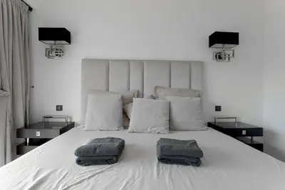 a bedroom with a white bed with two towels on it at Palais Des Iles - La Croisette by Halldis in Cannes