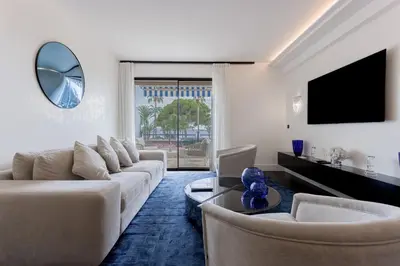 a living room with a couch and a tv at Palais Des Iles - La Croisette by Halldis in Cannes