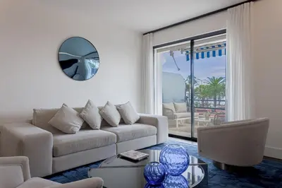 a living room with a couch and a mirror at Palais Des Iles - La Croisette by Halldis in Cannes