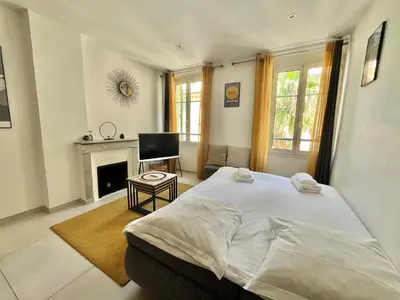 a bedroom with a large bed and a fireplace at Greyson apartment 3 from Palais by Welcome to Cannes in Cannes