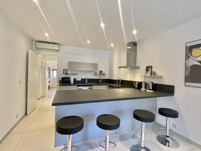 a kitchen with three bar stools and a counter at Greyson apartment 3 from Palais by Welcome to Cannes in Cannes