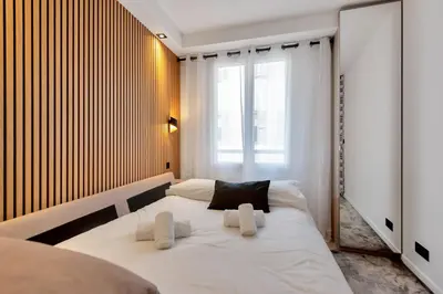 a large white bed in a room with a window at LE NAPOLEON chic et moderne, l'endroit parfait au cœur de la Banane in Cannes