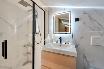 a white bathroom with a sink and a mirror at LE NAPOLEON chic et moderne, l'endroit parfait au cœur de la Banane in Cannes
