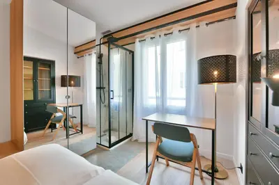 a bedroom with a desk and a bed and a table at LE NAPOLEON chic et moderne, l'endroit parfait au cœur de la Banane in Cannes