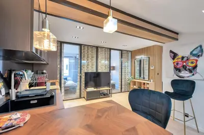 a living room with a couch and a television at LE NAPOLEON chic et moderne, l'endroit parfait au cœur de la Banane in Cannes