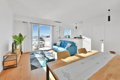 a living room with a blue couch and a table at LE MARINE vue mer avec joli terrasse, un rêve pour les couples in Cannes
