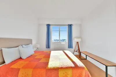 a bedroom with a large bed and a window at LE MARINE vue mer avec joli terrasse, un rêve pour les couples in Cannes