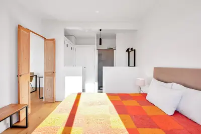 a bedroom with a bed with a colorful blanket on it at LE MARINE vue mer avec joli terrasse, un rêve pour les couples in Cannes