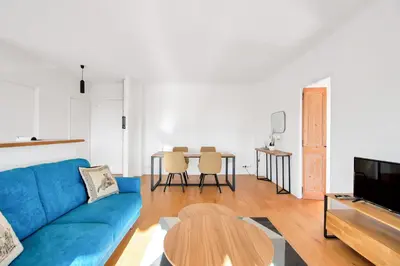 a living room with a blue couch and a table at LE MARINE vue mer avec joli terrasse, un rêve pour les couples in Cannes