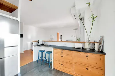 a kitchen with a wooden counter top and blue stools at LE MARINE vue mer avec joli terrasse, un rêve pour les couples in Cannes