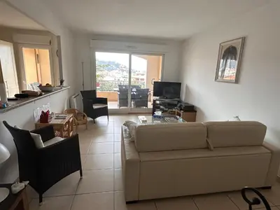 a living room with a couch and a table at 2 bedroom apartment with a pool in the heart of Cannes easy walk to the main beach on La Croisette - 2191 in Cannes