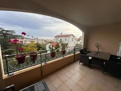 a room with a balcony with potted plants at 2 bedroom apartment with a pool in the heart of Cannes easy walk to the main beach on La Croisette - 2191 in Cannes