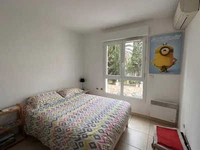 a bedroom with a bed and a window at 2 bedroom apartment with a pool in the heart of Cannes easy walk to the main beach on La Croisette - 2191 in Cannes