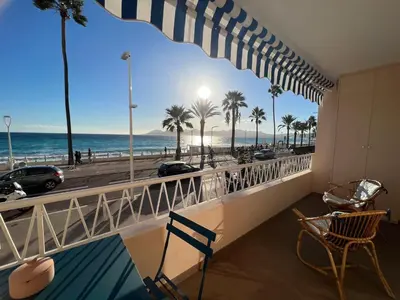 a balcony with a view of the beach and palm trees at Shelly luxury sea view by Welcome to Cannes in Cannes