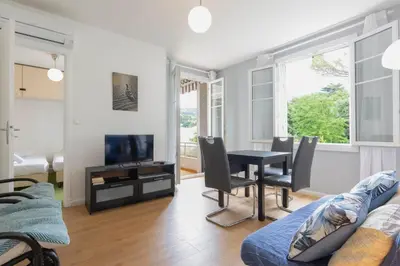 a living room with a table and a tv at Selvosa 1-bedroom apartment heart of Cannes in Cannes