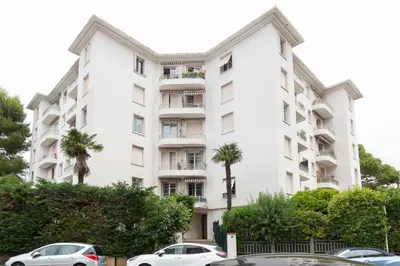 a white building with cars parked in front of it at Selvosa 1-bedroom apartment heart of Cannes in Cannes