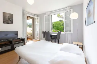 a living room with a white table and a tv at Selvosa 1-bedroom apartment heart of Cannes in Cannes