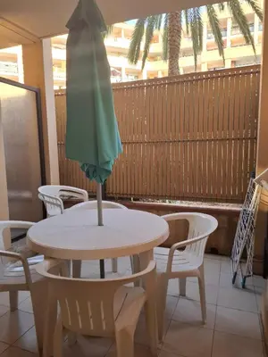 a table and chairs with a green umbrella on it at Appartement 3 pièces piscine proche plage et Cannes in Cannes