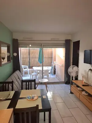 a living room with a couch and a table at Appartement 3 pièces piscine proche plage et Cannes in Cannes