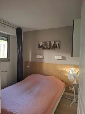 a bedroom with a bed and a lamp and a window at Appartement 3 pièces piscine proche plage et Cannes in Cannes