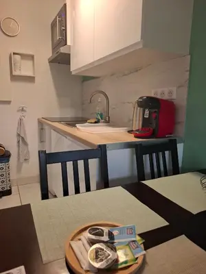 a kitchen with a sink and a table with a plate on it at Appartement 3 pièces piscine proche plage et Cannes in Cannes