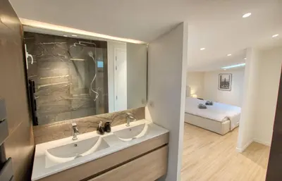 a bathroom with two sinks and a bed in a room at Maison Moderne Cannes 3 Chambres 3 Salles de Bain WIFI - LIMESTAY in Cannes