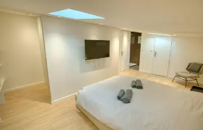 a bedroom with a bed and a tv on the wall at Maison Moderne Cannes 3 Chambres 3 Salles de Bain WIFI - LIMESTAY in Cannes