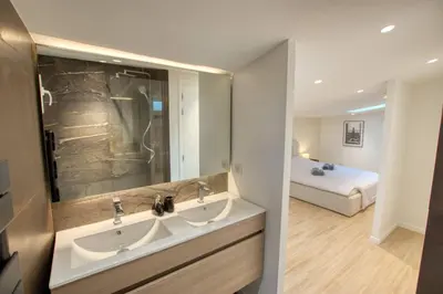 a bathroom with two sinks and a bed in a room at Maison Moderne Cannes 3 Chambres 3 Salles de Bain WIFI - LIMESTAY in Cannes