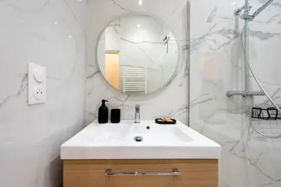 a bathroom with a white sink and a mirror at Renovated Apartment in the Heart of Cannes in Cannes