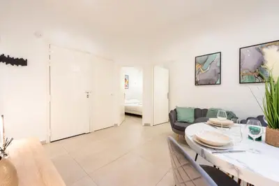 a living room with a table and a couch at Renovated Apartment in the Heart of Cannes in Cannes